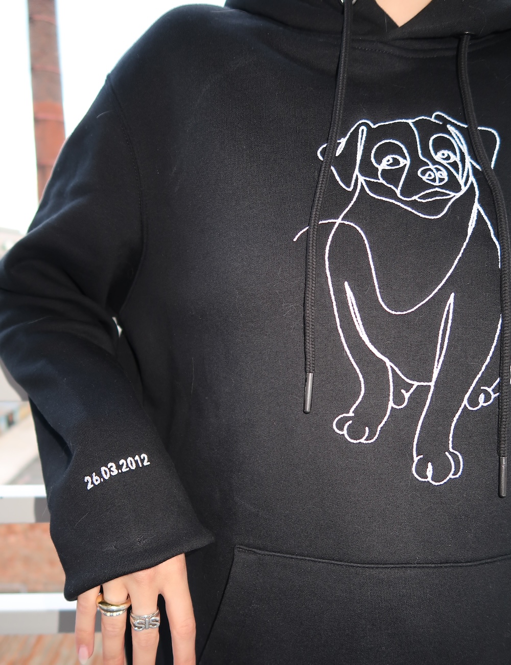 Zwarte hoodie hond gepersonaliseerd met borduring op mouw